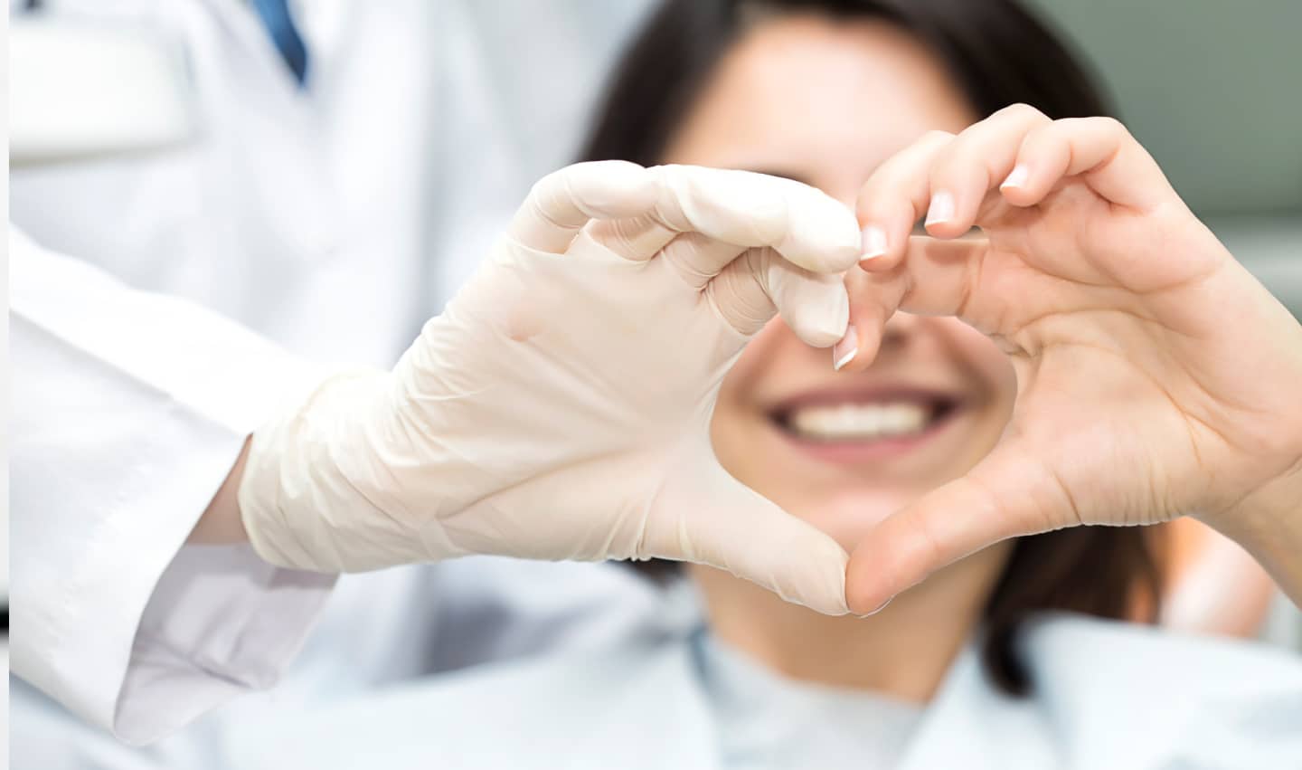 Doctor and patient makig a heart with their hands.
